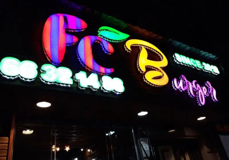 تابلو نئون چشمگیر و پرنور اف سی برگر در شب با حروف رنگارنگ FCB و کلمه Burger، به همراه شماره تماس و سال تاسیس 2011.