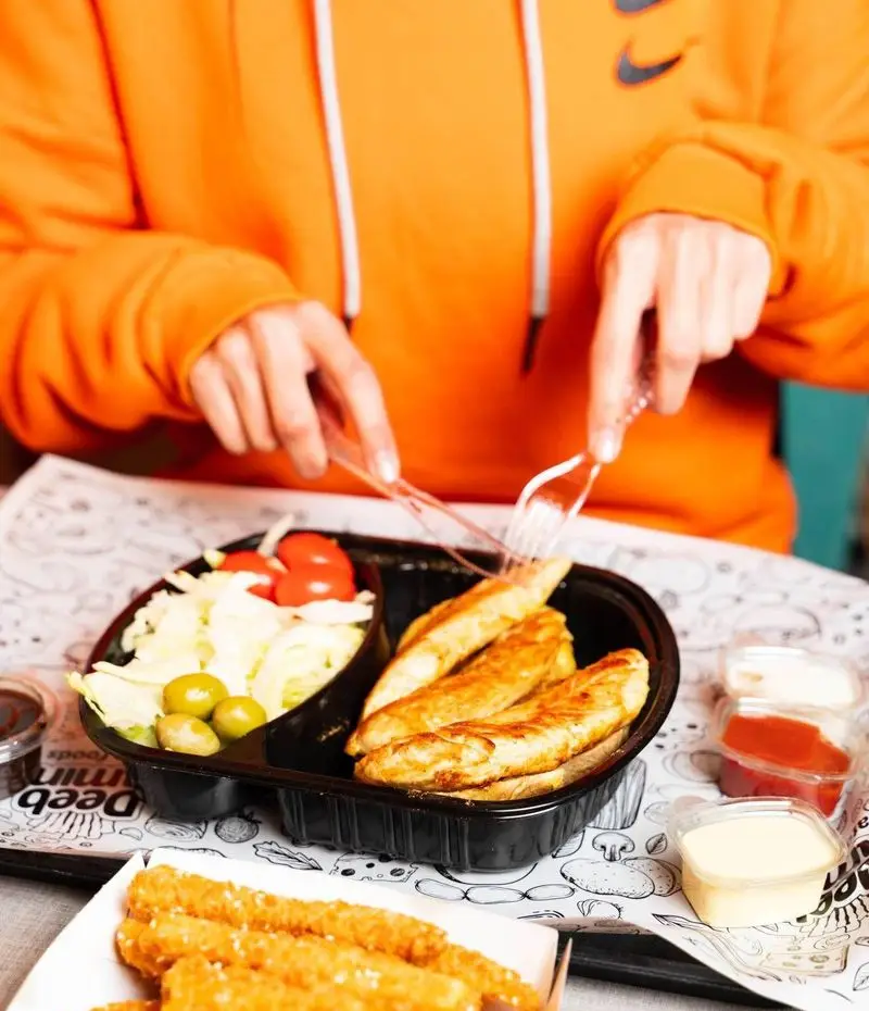 وعده غذایی لذیذ در دیب چیز سعادت آباد: چیکن استریپس، سالاد تازه با زیتون و گوجه، سس‌های خوش‌طعم و استیک‌های پنیر سوخاری.