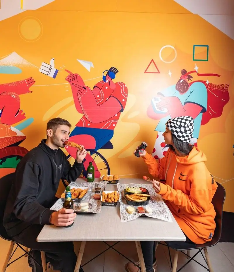 زوج جوان در رستوران دیب چیز شعبه سعادت آباد مشغول صرف انواع غذاهای خوشمزه، از پنیر سوخاری تا مرغ سوخاری در محیطی شاد.