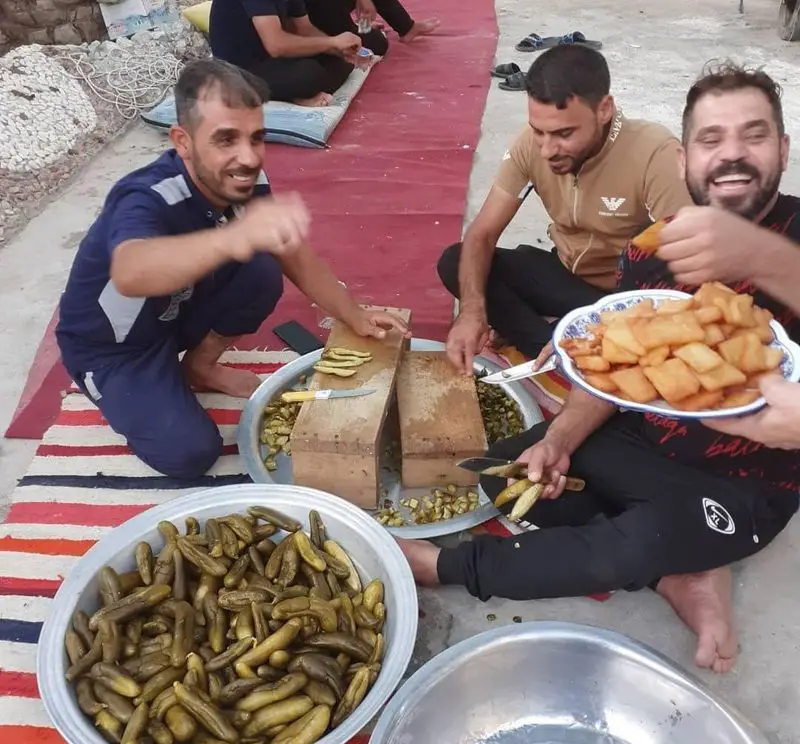 مردان در حال آماده‌سازی و لذت بردن از فلافل‌های تازه ابوحیدر. دورهمی دوستانه و پخت غذای سنتی و لذیذ فلافل.