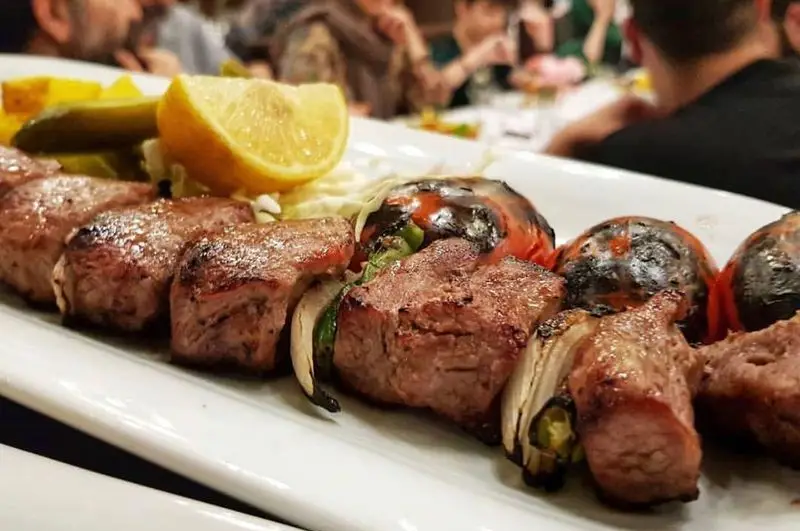 کباب چنجه گوشت تازه و آبدار در رستوران نایب ابان، سرو شده با گوجه کبابی، پیاز، لیمو و ترشی. تجربه غذای اصیل ایرانی و لذت بخش.