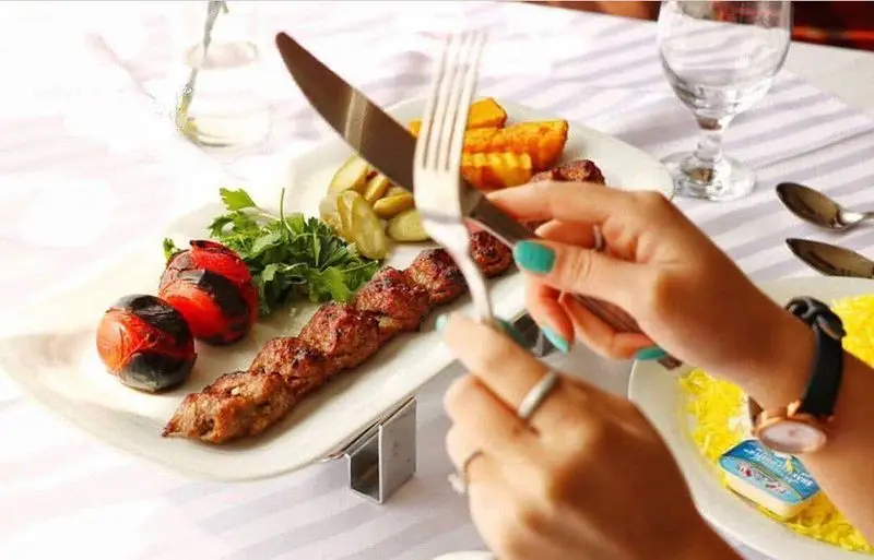 میز غذای مشتری در رستوران نایب ابان، شامل کباب کوبیده، گوجه کبابی و پلو زعفرانی. لذت چشیدن طعم اصیل غذای ایرانی.