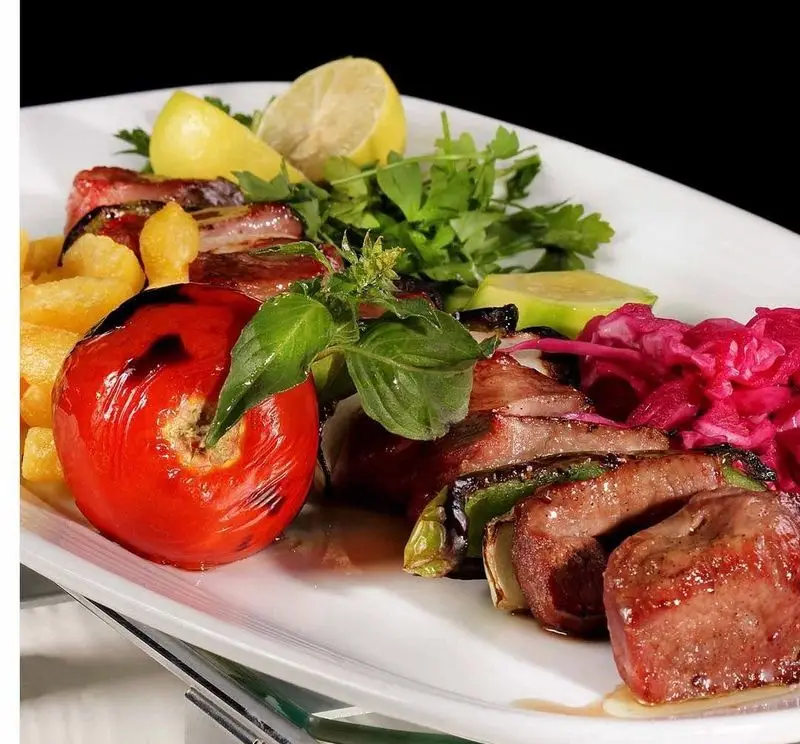 بشقاب کامل کباب چنجه و میکس گریل شامل گوجه کبابی، سیب زمینی سرخ کرده، لیمو، سبزیجات تازه و کلم قرمز از رستوران نایب ابان.