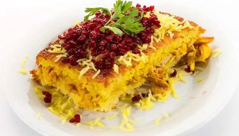 ته چین مرغ زعفرانی خوش رنگ و خوش طعم رستوران نایب ابان، با ته دیگ طلایی و تزیین زرشک و جعفری، غذای اصیل ایرانی