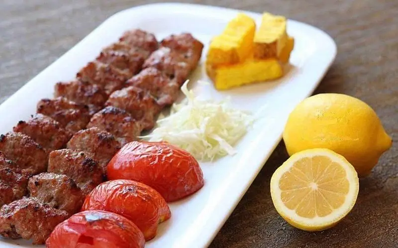 کباب کوبیده لذیذ رستوران نایب ابان، همراه با گوجه کبابی، کلم تازه، ته دیگ زعفرانی و لیموترش؛ تجربه‌ای اصیل از غذای ایرانی.