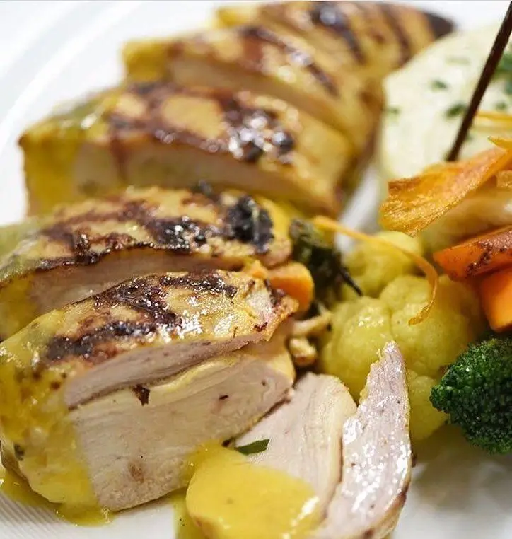 یک بشقاب شیک و لذیذ از سینه مرغ گریل شده با سس مخصوص و دورچین سبزیجات متنوع در رستوران نایب ابان. انتخابی عالی برای وعده شام.