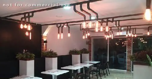 دکوراسیون داخلی مدرن و صنعتی رستوران پیتزا سیب ۳۶۰ با نورپردازی گرم، میز و صندلی شیک، فضایی دلنشین برای مشتریان.