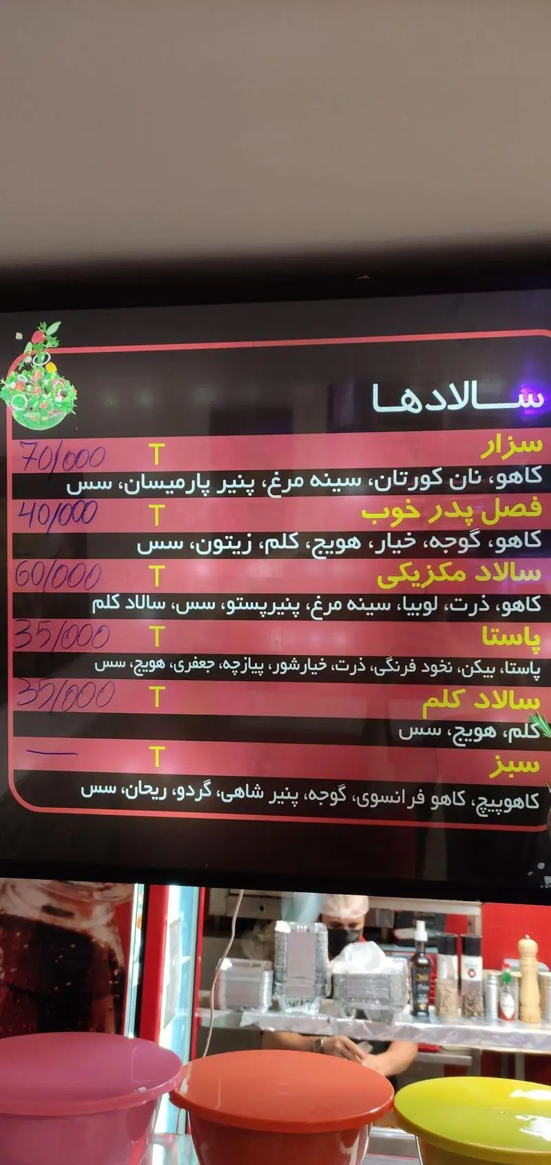 منوی فست فود پدرخوب: سالادهای سزار (مرغ، پارمیسان)، مکزیکی، پاستا، کلم و سبزیجات تازه با قیمت‌های مشخص روی تابلو دیجیتال.