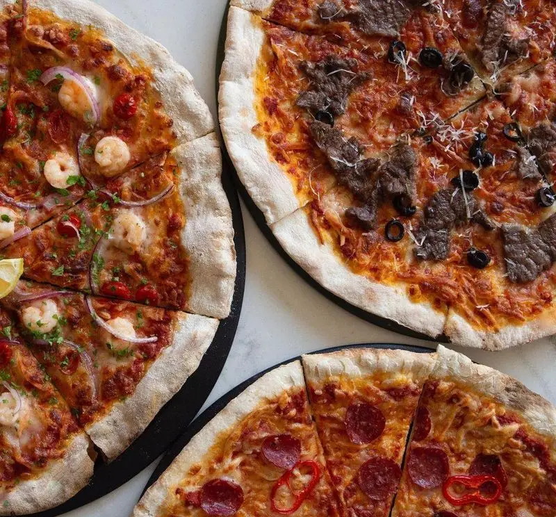 عکس سه پیتزای تازه و خوشمزه از رستوران پیتزا پای شامل پیتزای میگو، پیتزا گوشت و پیتزای پپرونی تند برای طرفداران پیتزا.