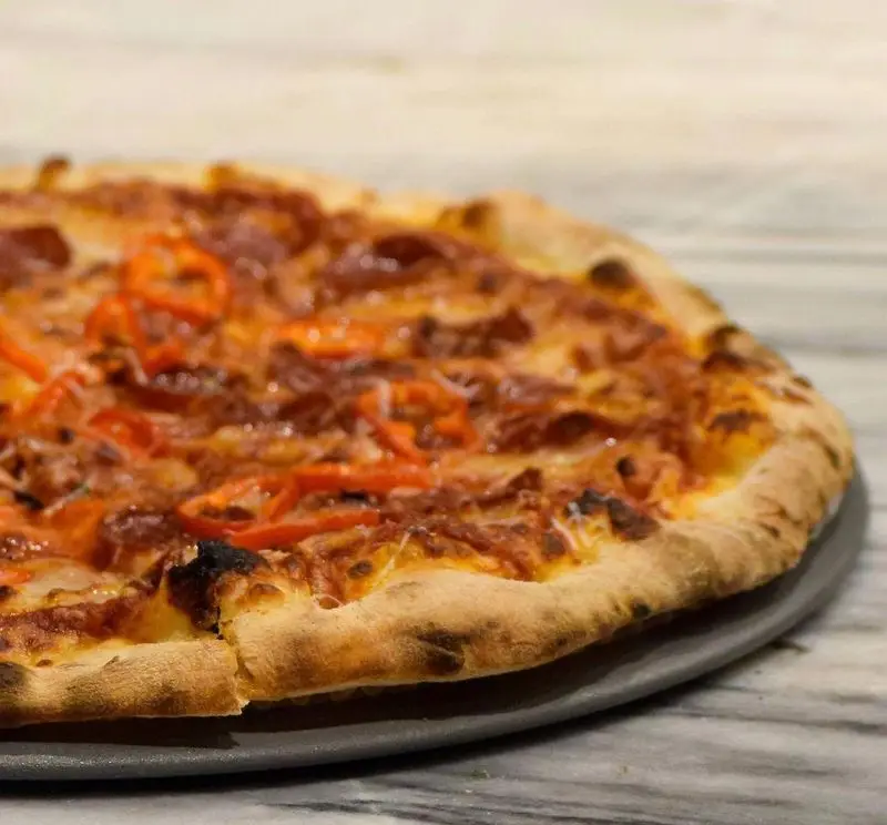پیتزا دستپخت و داغ پیتزا پای با پنیر فراوان، فلفل‌های خوشرنگ و خمیر ترد، آماده برای یک تجربه غذایی بی‌نظیر و لذیذ. کیفیت عالی.