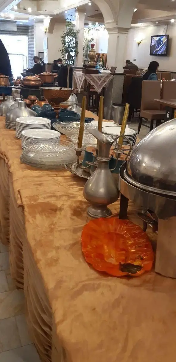 نمایی از بوفه سلف سرویس چلوکبابی نصرت. میز پذیرایی باشکوه با انواع ظروف مسی، پلوپزهای گرم و بشقاب‌های آماده در محیط دلنشین رستوران.