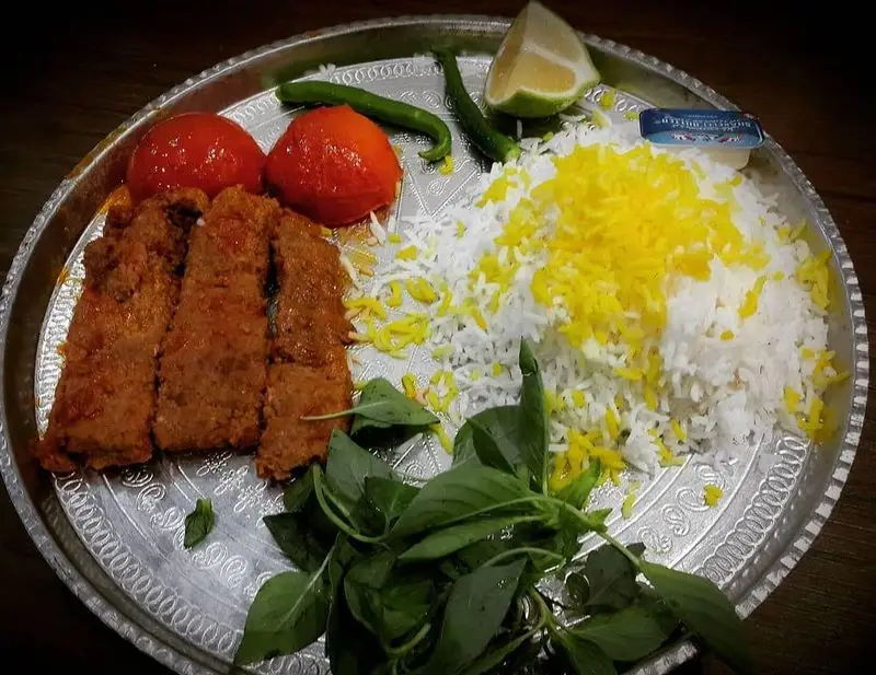 چلوکباب کوبیده نصرت با برنج زعفرانی، گوجه کبابی، فلفل سبز، ریحان تازه و لیموی ترش، غذایی دلپذیر از چلوکبابی نصرت.