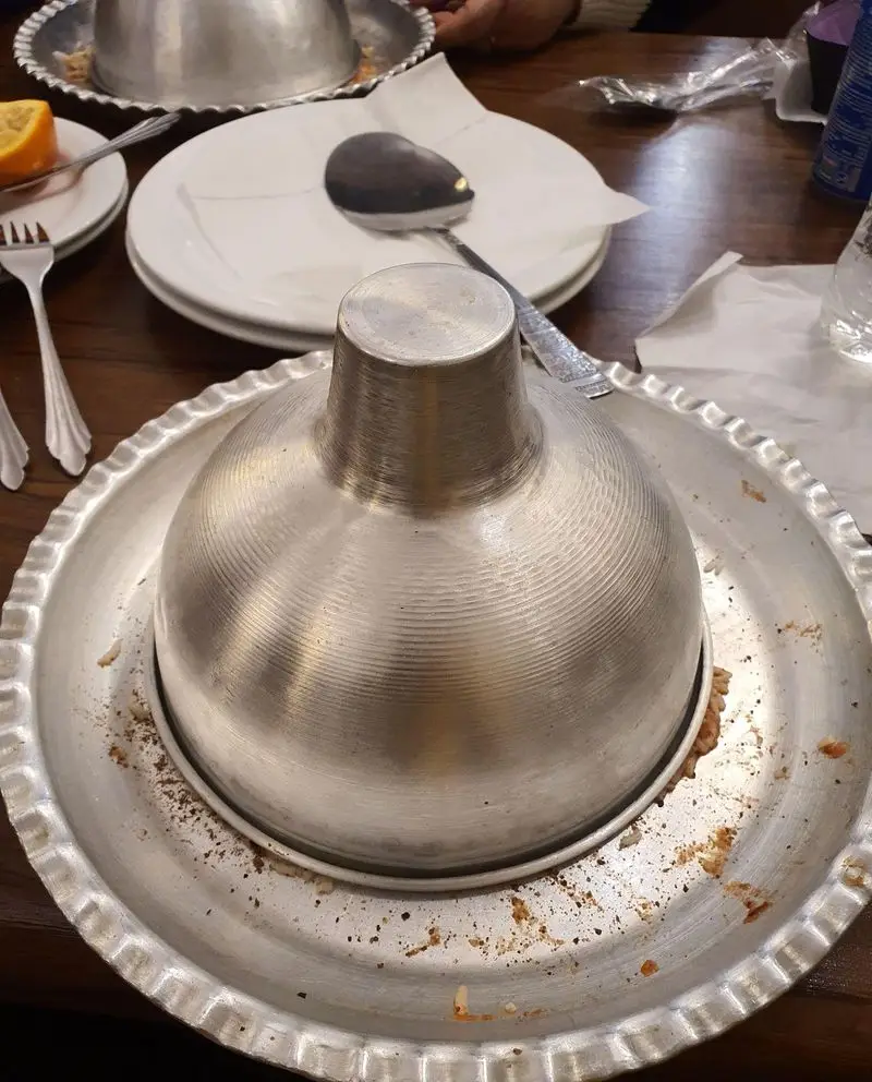 میز شام در چلوکبابی نصرت، با سینی فلزی و درب گنبدی جذاب برای سرو غذا. لذت یک وعده کباب ایرانی اصیل در فضایی دلنشین.
