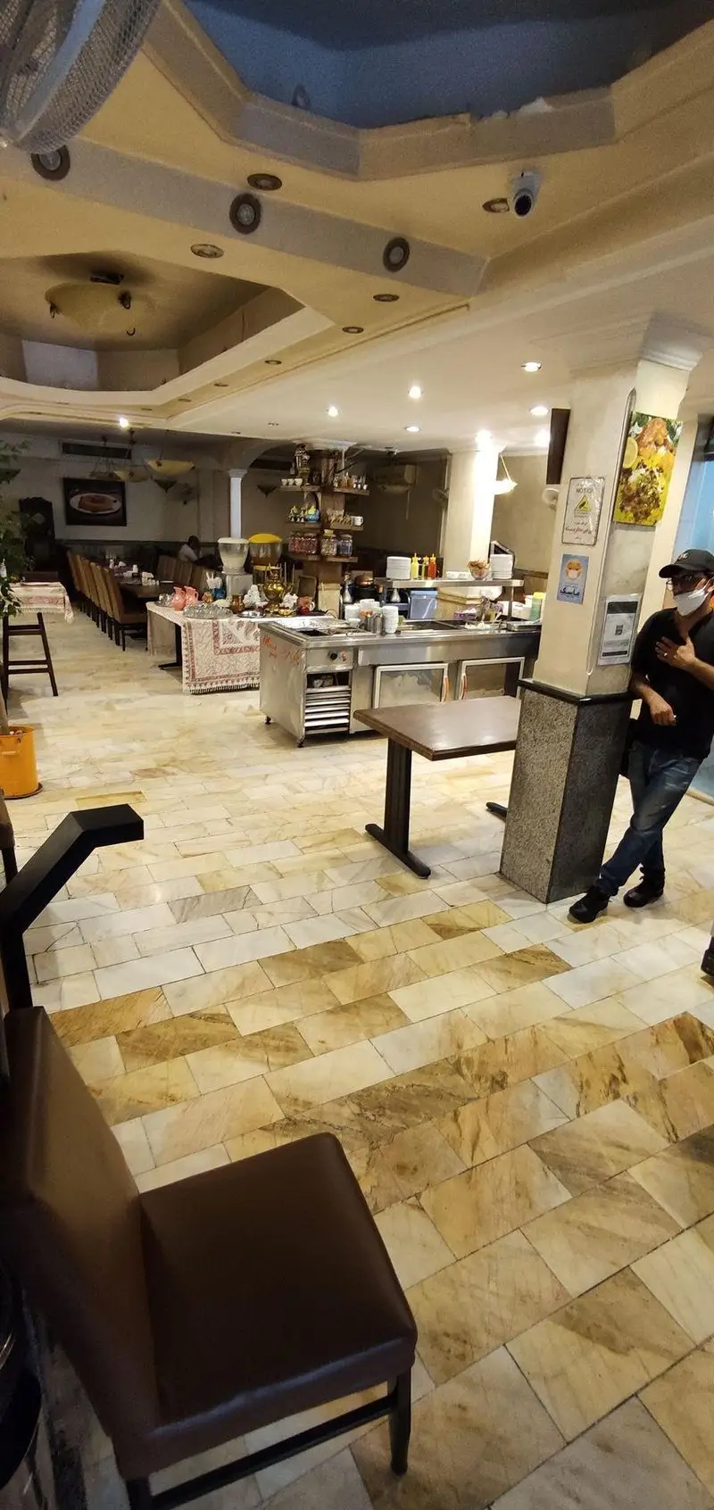 فضای داخلی شیک و دلنشین چلوکبابی نصرت با میز و صندلی‌های مرتب، پیشخوان سلف سرویس و دکوراسیون ایرانی. مناسب برای صرف غذای سنتی.