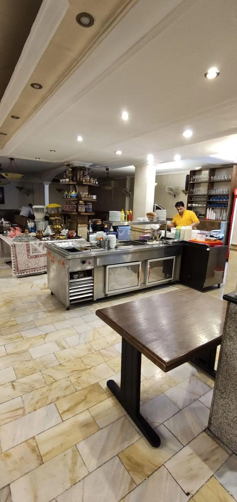 فضای داخلی دنج و دلنشین چلوکبابی نصرت با پیشخوان آماده سرو غذا، میزهای تمیز و پرسنل فعال، مناسب برای تجربه لذیذ کباب ایرانی.