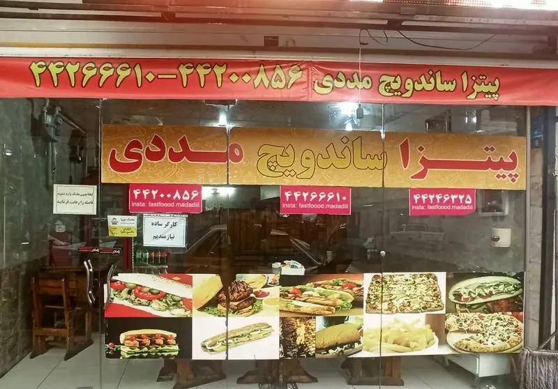 تصویر ویترین فست فود پیتزا ساندویچ مددی. انواع پیتزا، ساندویچ، برگر و سیب‌زمینی سرخ کرده. شماره تماس و اینستاگرام fastfoood.madadiii.