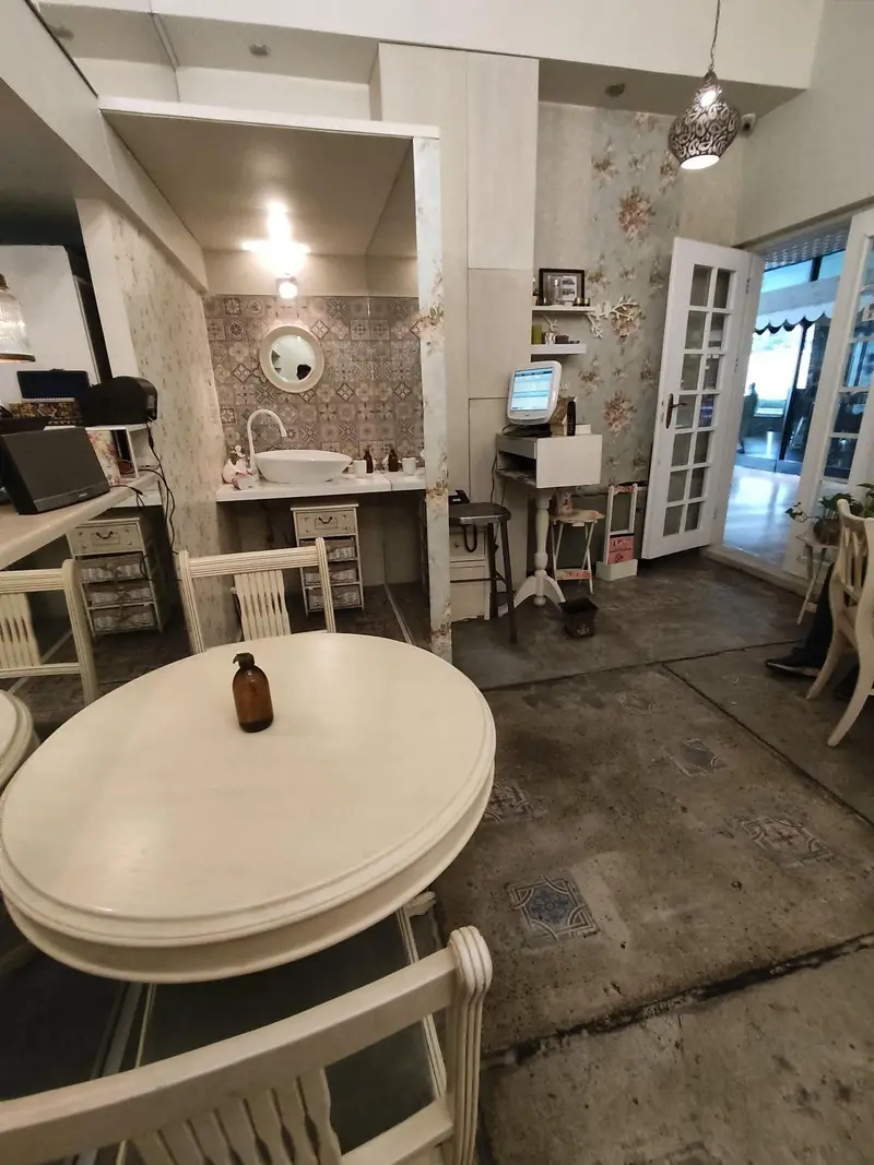 فضای داخلی رستوران گیاهی پیور با میزهای سفید چوبی شیک، دکوراسیون دلنشین و سینک روشویی زیبا، محیطی آرام و تمیز برای صرف غذا.