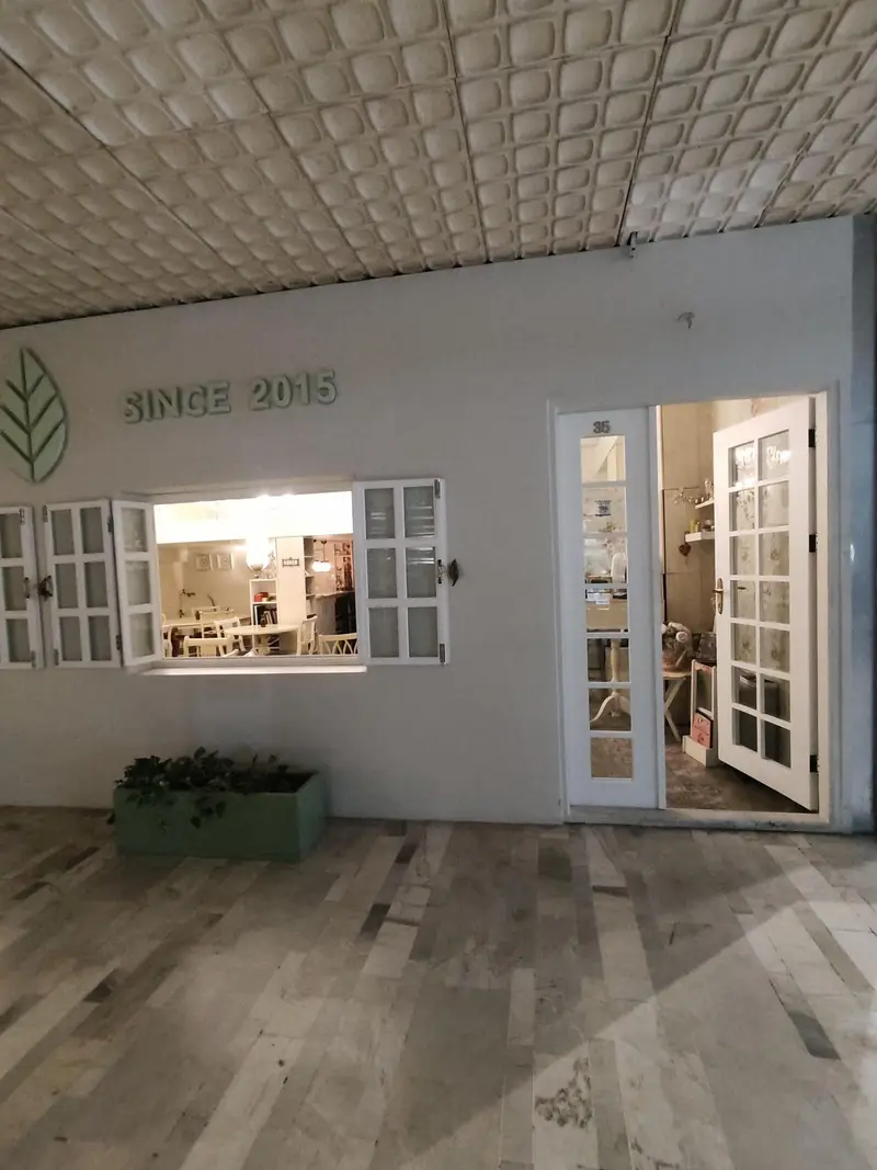 نمای بیرونی رستوران گیاهی پیور با لوگوی برگ و "SINCE 2015". ورودی با پنجره باز، درب شیشه‌ای شماره ۳۵ و دکوراسیون داخلی روشن.