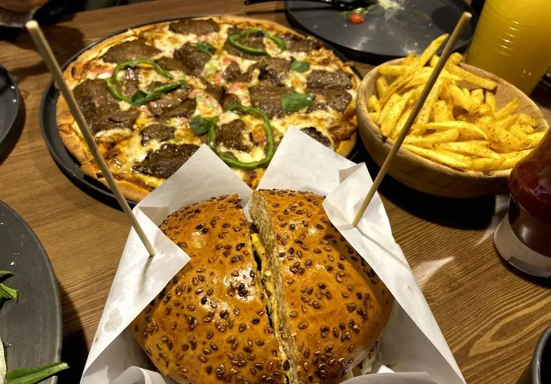 لذت طعم بی نظیر پیتزا استیک، همبرگر دست ساز، سیب زمینی ترد و نوشیدنی گوارا در فست فود پیله برای یک تجربه خاص.