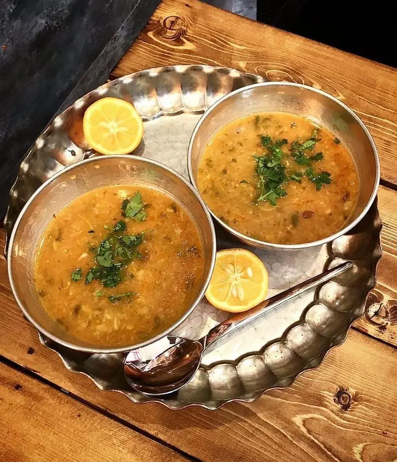 دو کاسه سوپ گرم، لذیذ و سنتی ایرانی با سبزی تازه و لیمو، سروی عالی از کباب و جگر سرای عمو هوشنگ برای مشتریان.