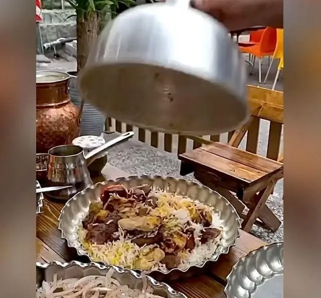 لحظه سرو کباب و جگر پلو لذیذ در کباب و جگر سرای عمو هوشنگ، تجربه غذای اصیل ایرانی در رستورانی با فضای دلنشین.