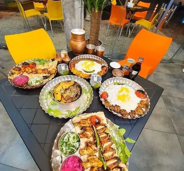 سفره‌ای پر از انواع کباب، جوجه کباب و کوبیده لذیذ با پلو و مخلفات در کباب و جگر سرای عمو هوشنگ با محیطی دنج و سنتی.