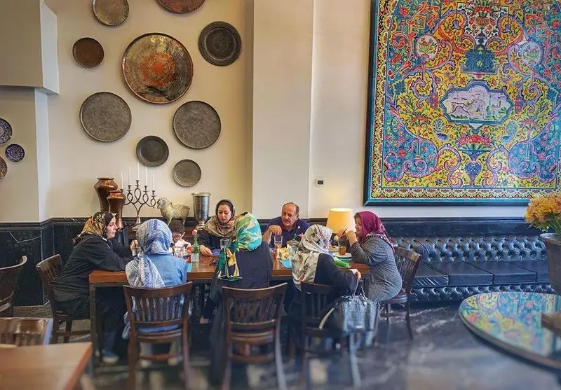 فضای دلنشین رستوران اصیل با دکوراسیون سنتی و تابلوهای مسی، محلی گرم برای دورهمی خانوادگی و صرف غذای ایرانی.