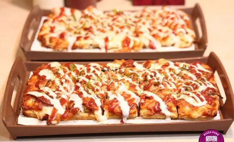 سفارش دو پیتزای مستطیلی بزرگ از پیتزا پارک با رویه پر از سس، پنیر و مخلفات عالی برای دورهمی‌ها.