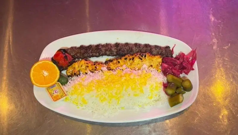 چلو کباب کوبیده خوشمزه کافه رستوران آرشیو با برنج زعفرانی، گوجه کبابی، کره، پرتقال و ترشی؛ غذای سنتی ایرانی برای ناهار و شام.