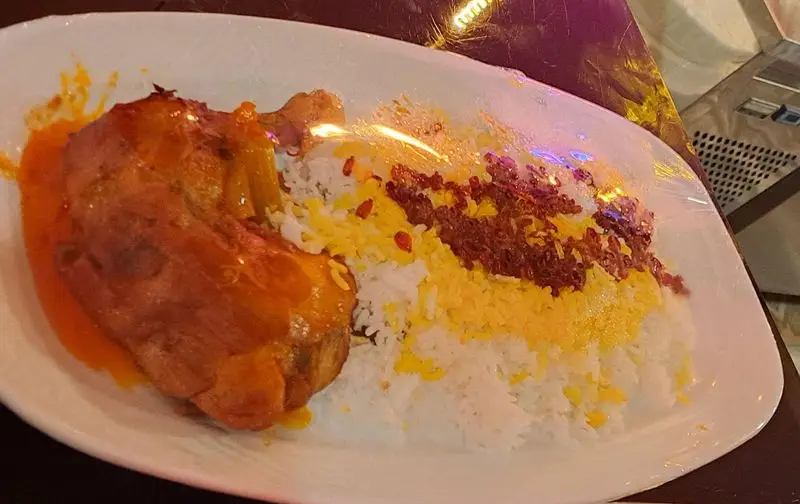 غذای سنتی و دلپذیر کافه رستوران آرشیو: ران مرغ آبدار با سس مخصوص، همراه با برنج زعفرانی و زرشک پلو.