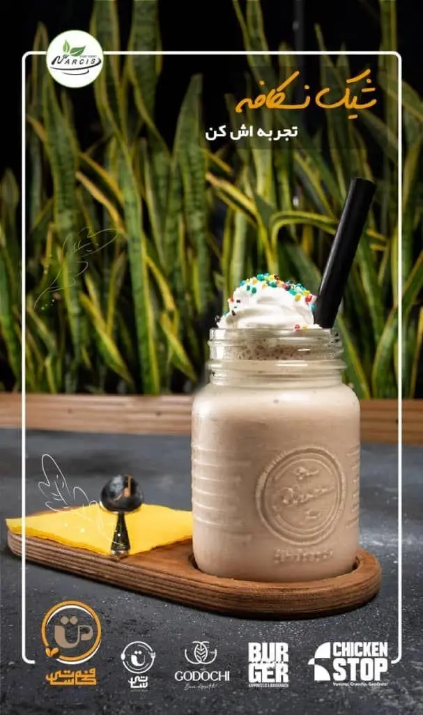 میلک شیک تازه با خامه و ترافل رنگی در لیوان شیشه‌ای زیبا، بخشی از منو نوشیدنی‌های فودهال نارسیس و کافه فودی شاپ.