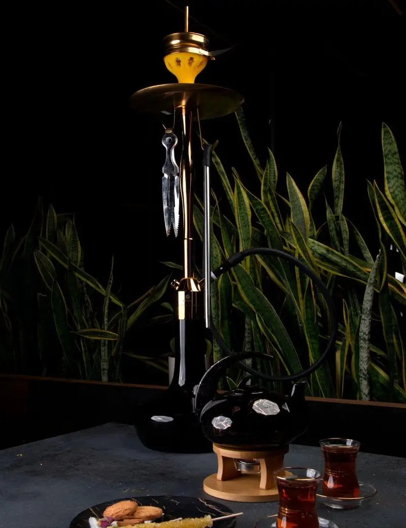 قلیان لاکچری طلایی، قوری چای مشکی روی وارمر، چای و نبات در فودهال نارسیس. محیطی دنج برای استراحت و دورهمی.