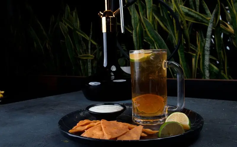 تصویری از نوشیدنی خنک، اسنک ترد و سس، با قلیان مدرن در فضای دلنشین فودهال نارسیس. لذت یک عصرانه خاص.