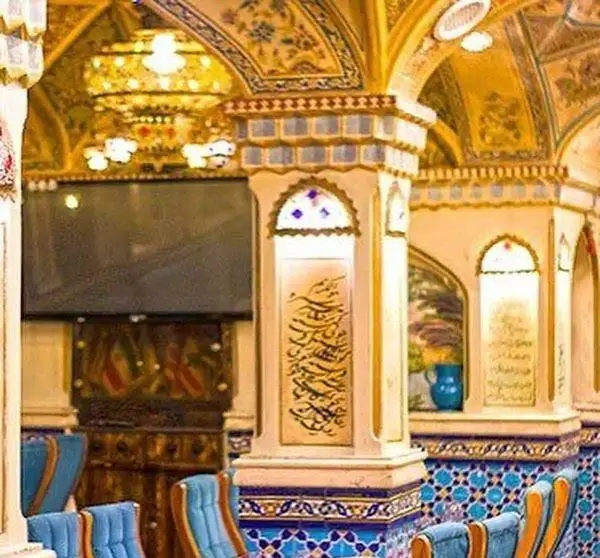 دکوراسیون داخلی باشکوه رستوران دف با سقف‌های طلاکاری شده، ستون‌های کاشیکاری و خوشنویسی، محیطی دلنشین و سنتی برای صرف غذا.