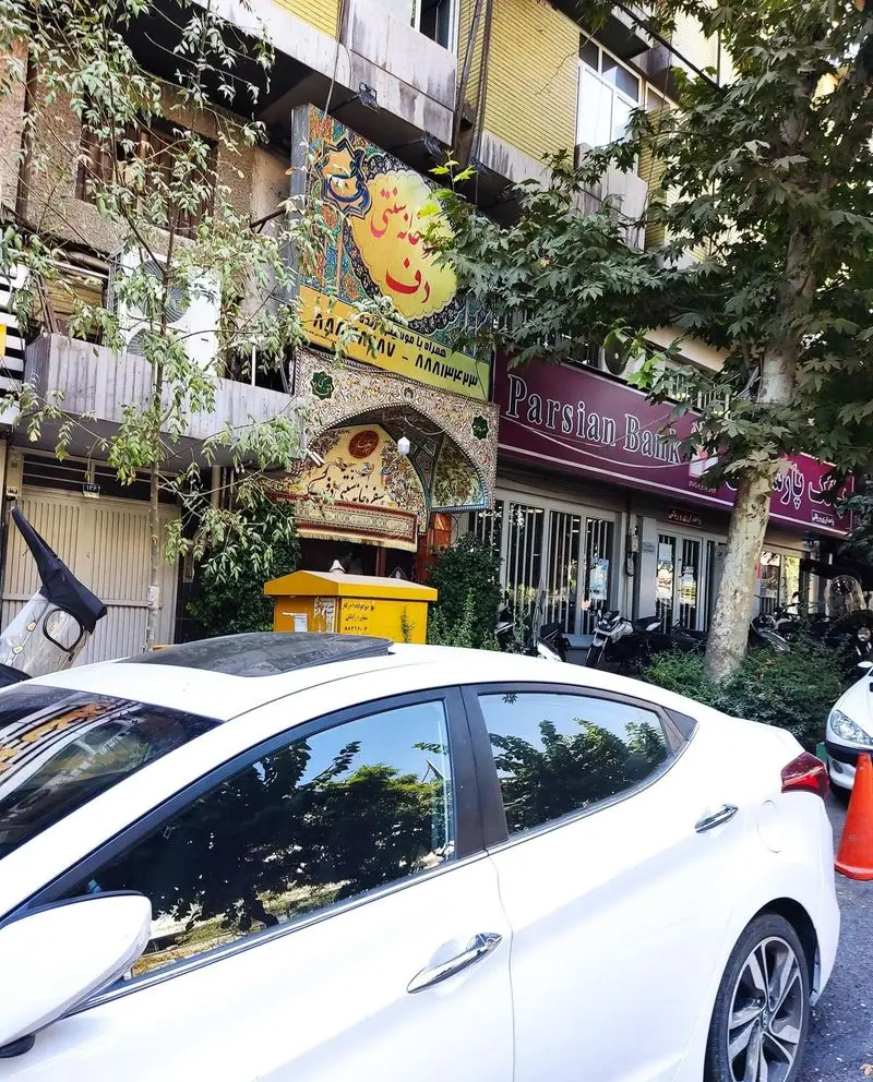 نمای بیرونی رستوران سنتی دف در تهران با تابلوی رنگارنگ و ورودی سنتی زیبا، در کنار شعبه بانک پارسیان. مناسب غذای ایرانی.