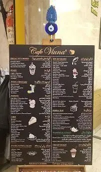 منوی کافه ویونا روی تخته‌ای مشکی با خط سفید گچی، نمایشگر انواع قهوه، نوشیدنی، دسر و غذاهای سبک کافه در محیطی آرام.