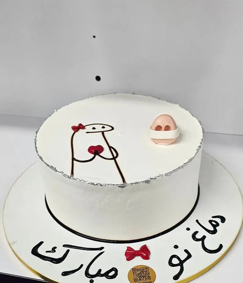 کیک زیبای سفید شیرینی خاتون با طراحی شخصیت محبوب فلورک، پاپیون قرمز و قلب، به همراه یک بینی بامزه. مناسب جشن و تبریک.