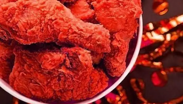 مرغ سوخاری قرمز و اسپایسی بازلیکو آریانو در سطل سفید، با روکش ترد و طعمی هیجان‌انگیز، بهترین انتخاب برای دورهمی‌ها.