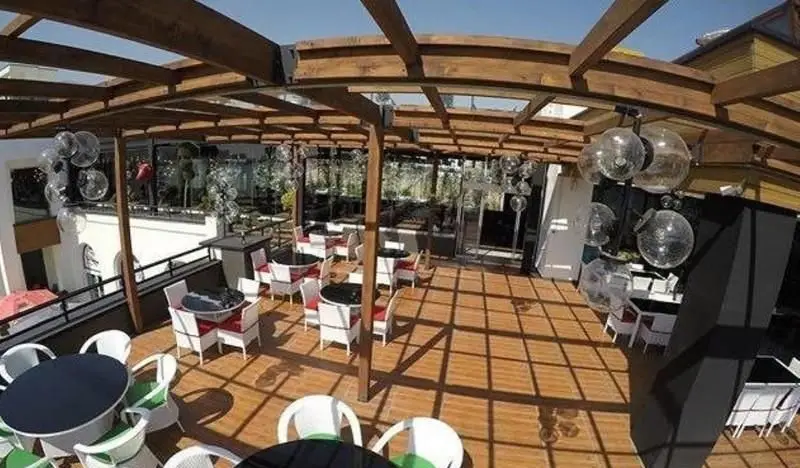 تصویری دلنشین از فضای باز و روف گاردن رستوران ایرانی ته دیگ، با طراحی چوبی و میزهای شیک، محیطی ایده‌آل برای صرف غذای ایرانی.