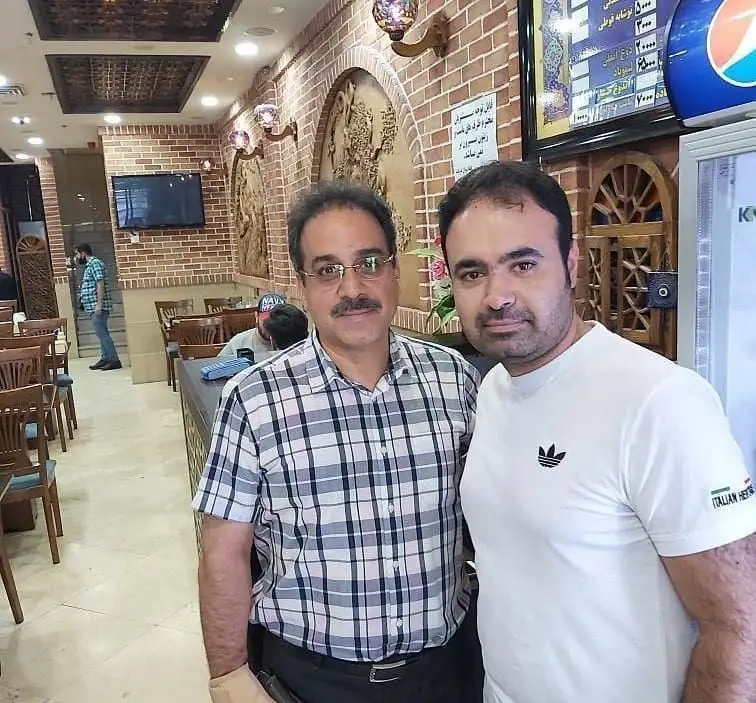 فضای داخلی زیبای رستوران جگرکی اردبیل با دکوراسیون آجری، دو نفر ایستاده و منوی غذا در پس‌زمینه