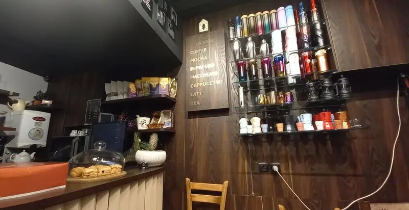 فضای داخلی گرم کافه دانژه با منوی کامل قهوه (اسپرسو، موکا، لاته، کاپوچینو، ماکیاتو)، چای و دسر.