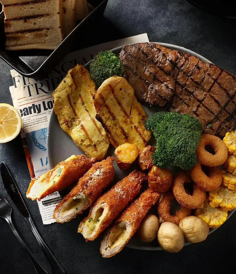 بشقاب غذای کامل و لذیذ از رستوران ایتالیایی آلین: استیک، مرغ گریل و سوخاری، بروکلی، پیاز حلقوی، ذرت و سیب زمینی.