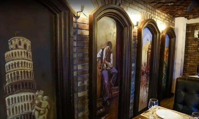 فضای داخلی جذاب رستوران ایتالیایی آلین با نقاشی‌های دیواری سه‌بعدی از برج پیزا و یک نوازنده، ایده‌آل برای یک وعده خاص.