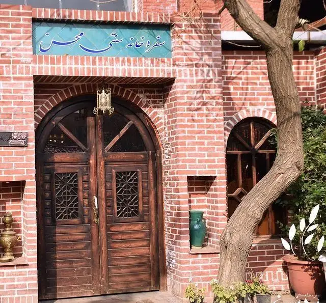 ورودی سفره خانه سنتی و زیبای باغچه محسن با درب چوبی قدیمی، نمای آجری و فضای دلنشین سنتی.