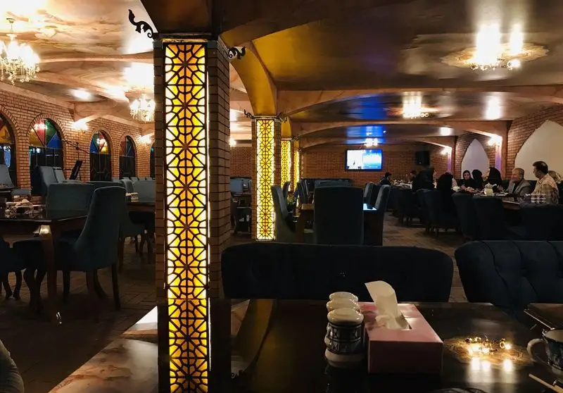 رستوران باغچه محسن، فضایی دنج و دلنشین با معماری سنتی ایرانی، دیوارهای آجری، نورپردازی خاص و مبلمان شیک برای مهمانان.