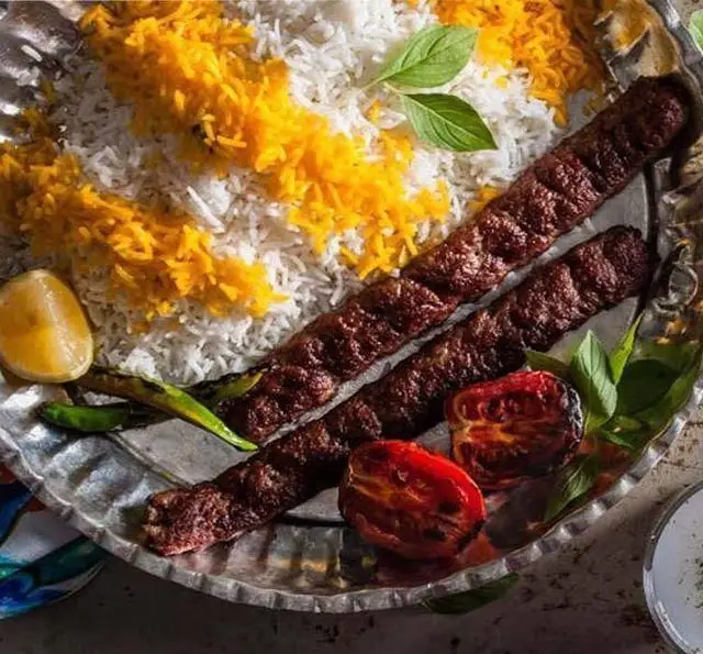 کباب کوبیده سنتی باغچه محسن، سرو شده با پلو زعفرانی، گوجه کبابی، فلفل و لیمو تازه. طعم بی‌نظیر غذای اصیل ایرانی.