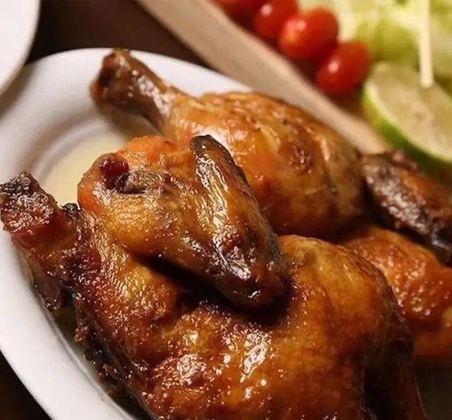 تکه‌های مرغ بریان طلایی و آبدار باغچه محسن، با سس ویژه و دورچین‌های تازه شامل گوجه گیلاسی و لیمو.