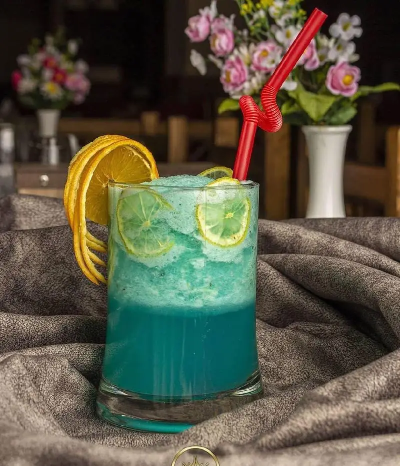 نوشیدنی خنک و تابستانی آبی رنگ کافه گل زعفرون، اسموتی میوه ای با لیمو و پرتقال تازه در فضایی دلنشین و آرامش بخش.