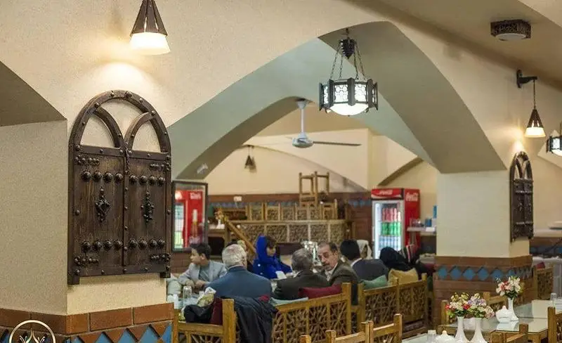 تصویری از فضای دلنشین و داخلی رستوران سنتی گل زعفرون، با دکوراسیون زیبای ایرانی، طاق‌های منحصر به فرد و مشتریان در حال صرف غذا.
