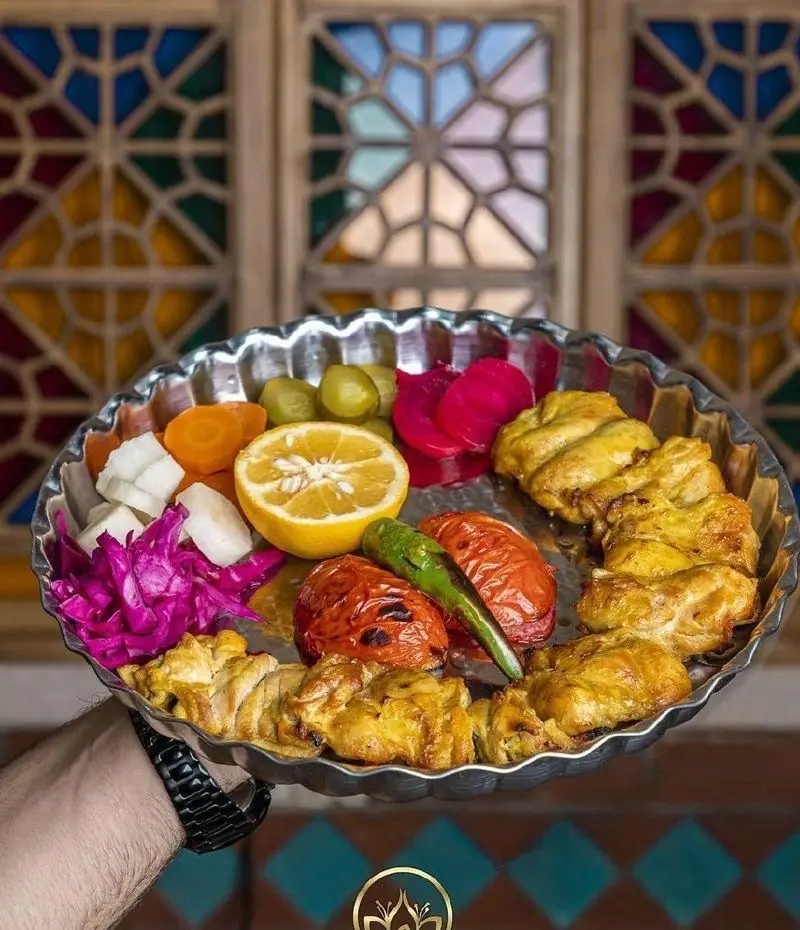 سینی دلپذیر جوجه کباب زعفرانی گل زعفرون با گوجه و فلفل کبابی، لیمو و ترشیجات متنوع در محیطی اصیل و دلنشین.